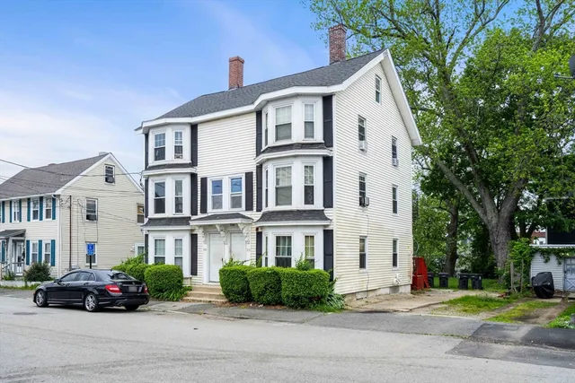 a car parked in front of a white house