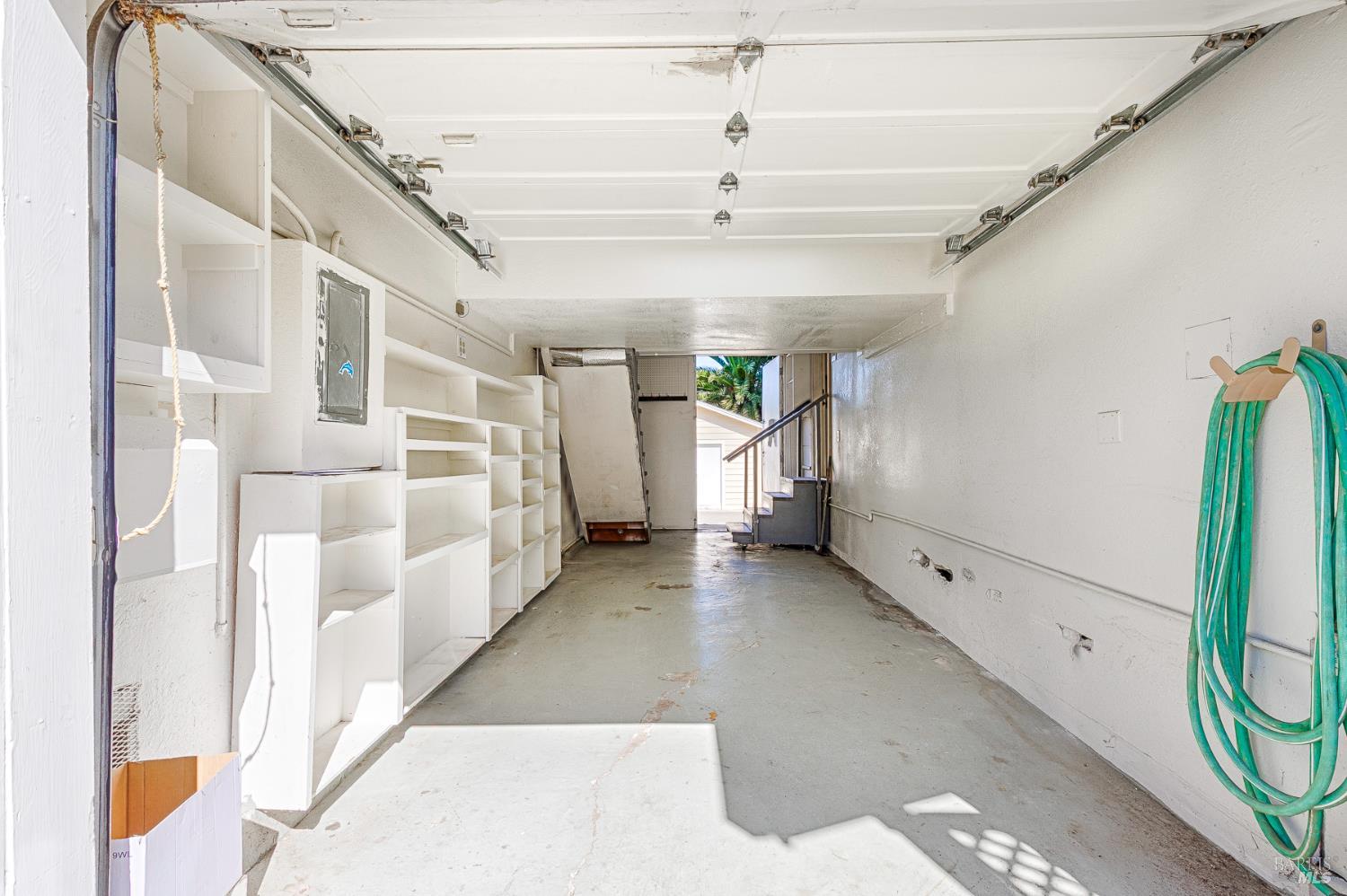 41 Meadow Avenue San Rafael, CA 94901 - Photo 23 of 55 This is the garage. The stairs on the left are on a pulley system and can be lifted up. The stairs on the right are on wheels. These stairs can be unhooked and moved away to allow for a full pass-through. There are double doors at the back that open. Only one side is open in this picture.