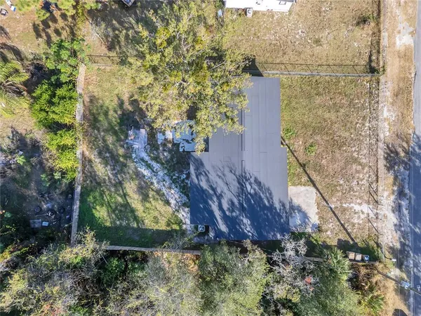 a aerial view of a house with a yard and large tree