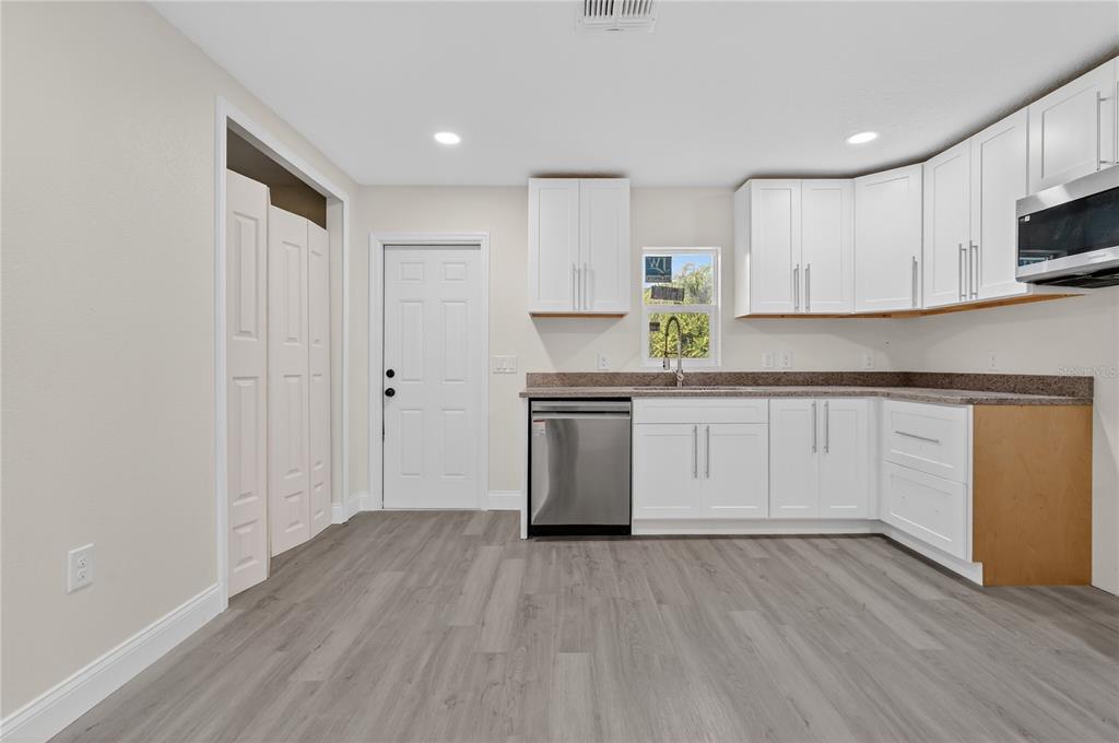 40415 Country Road Eustis, FL 32736 - Photo 29 of 39 a kitchen with a white cabinets and wooden floor
