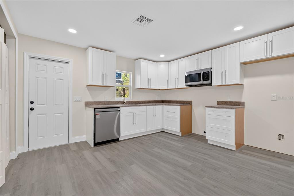 40415 Country Road Eustis, FL 32736 - Photo 30 of 39 a kitchen with white cabinets and stainless steel appliances