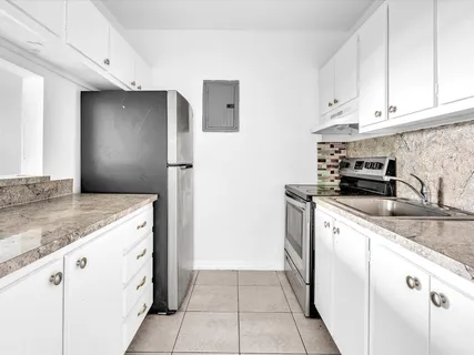 a kitchen with granite countertop white cabinets and white appliances