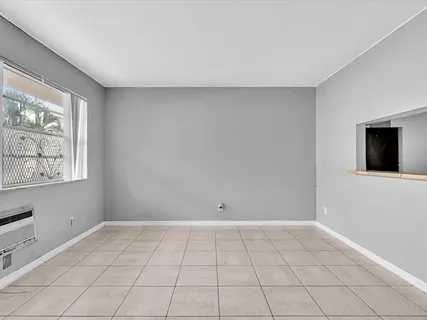 a view of an empty room with window and cabinet