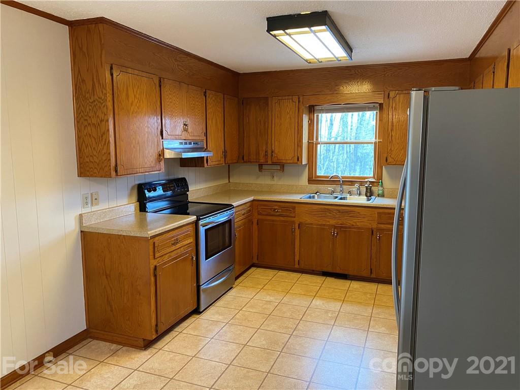 126 Burma Road West Marion, NC 28752 - Photo 22 of 29 a kitchen with stainless steel appliances a sink window and cabinets