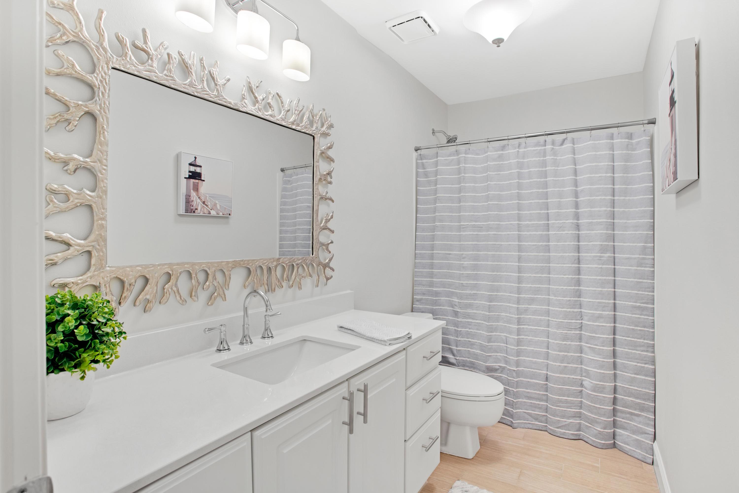 a bathroom with a sink a toilet and shower curtain