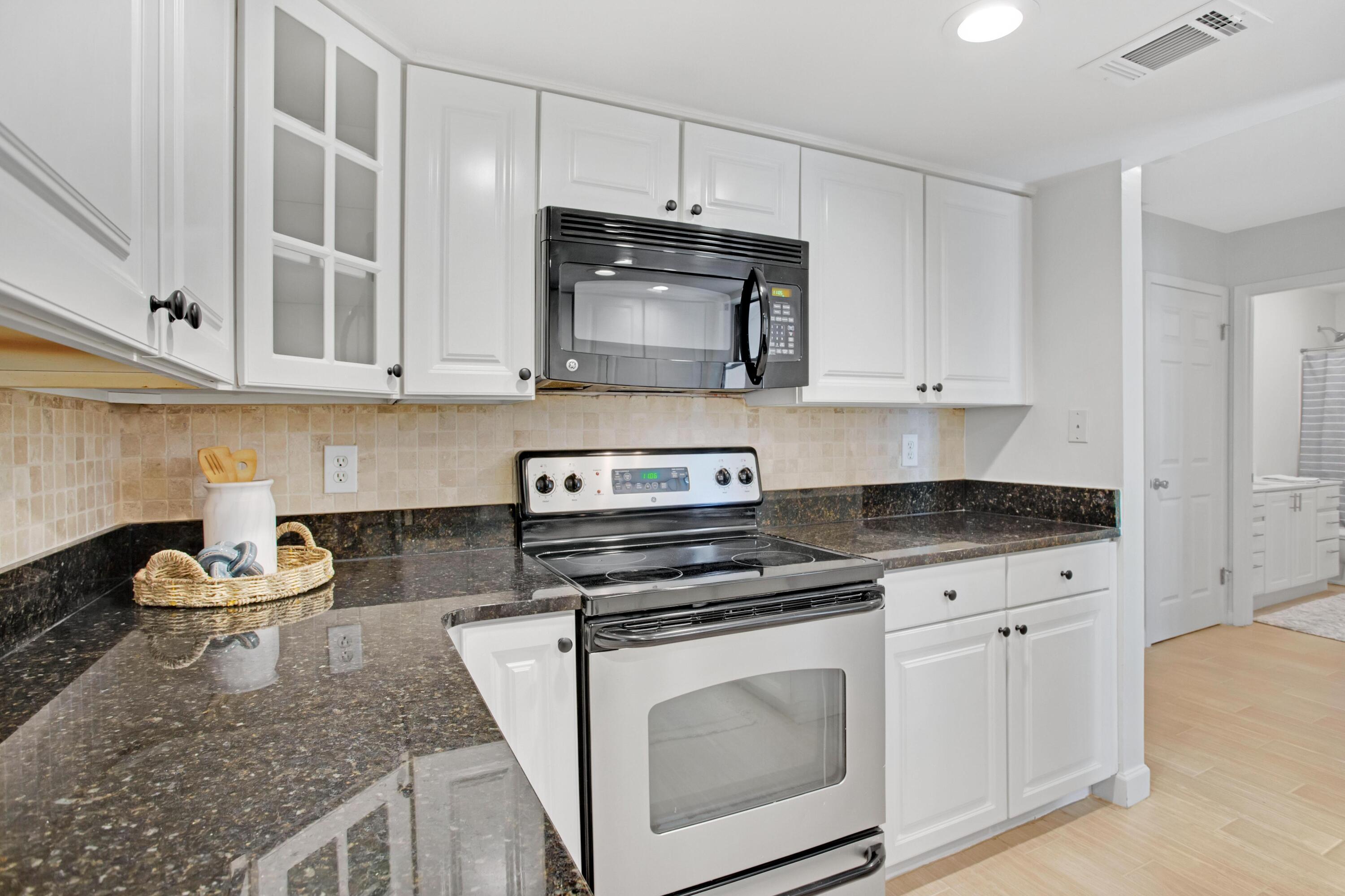 666 Bayou Drive, Unit 666 Miramar Beach, FL 32550 - Photo 11 of 24 a kitchen with white cabinets and appliances