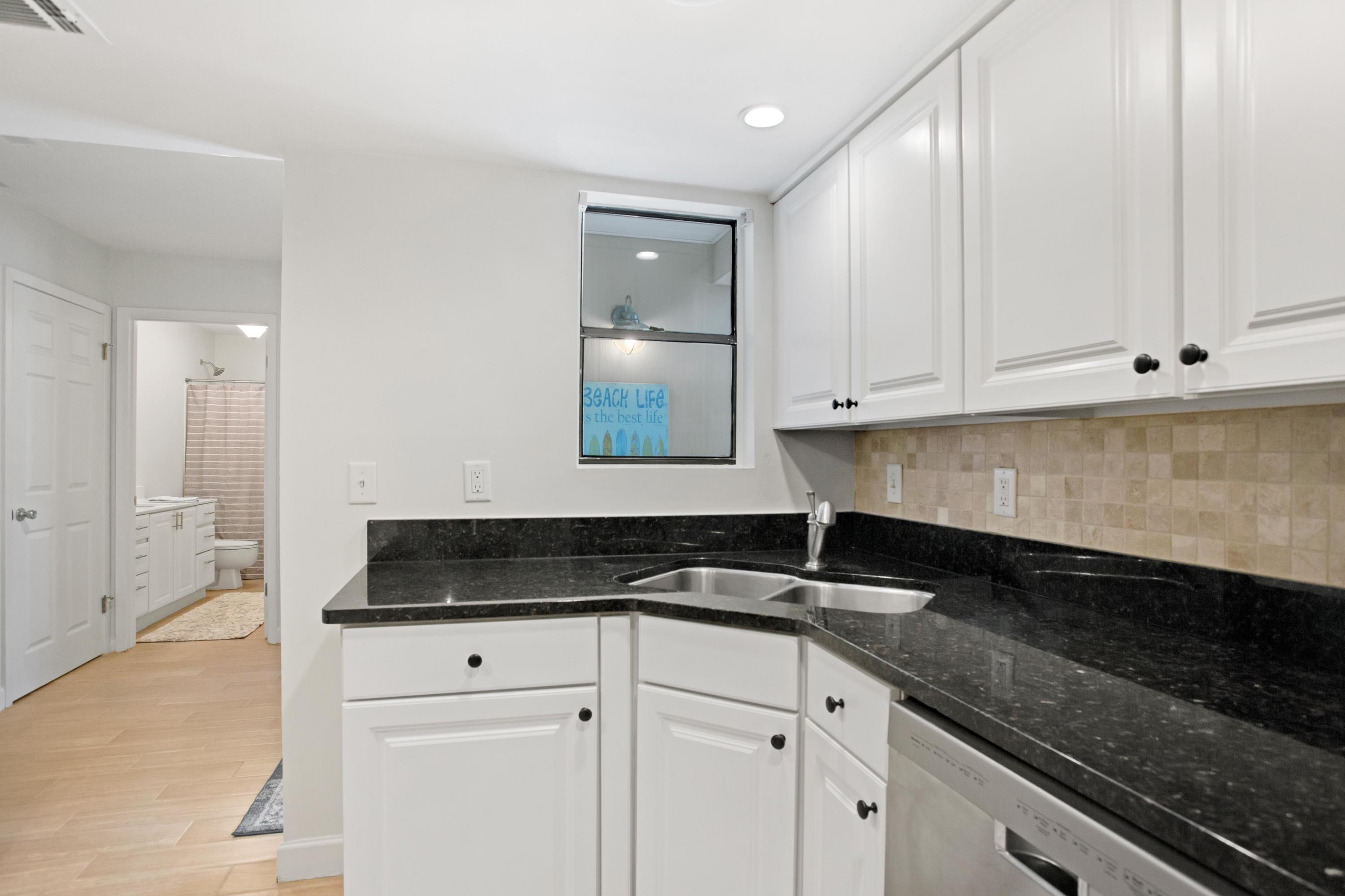 666 Bayou Drive, Unit 666 Miramar Beach, FL 32550 - Photo 12 of 24 a kitchen with granite countertop white cabinets and sink