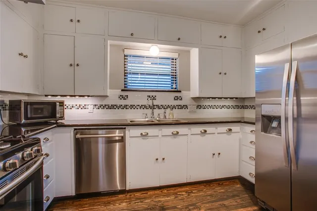 a kitchen with granite countertop cabinets stainless steel appliances and a sink