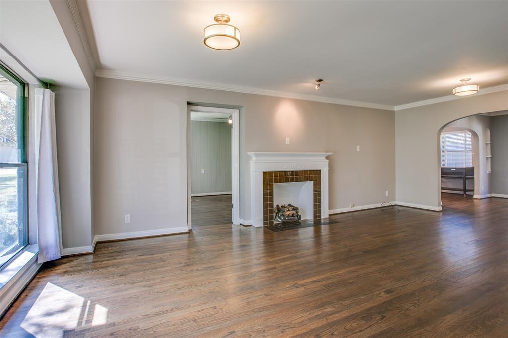 2051 Marydale Road Dallas, TX 75208 - Photo 5 of 30 an empty room with wooden floor a fireplace and windows
