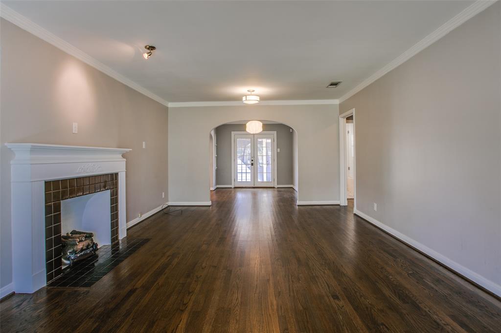 2051 Marydale Road Dallas, TX 75208 - Photo 6 of 30 a view of an empty room with wooden floor and a fireplace