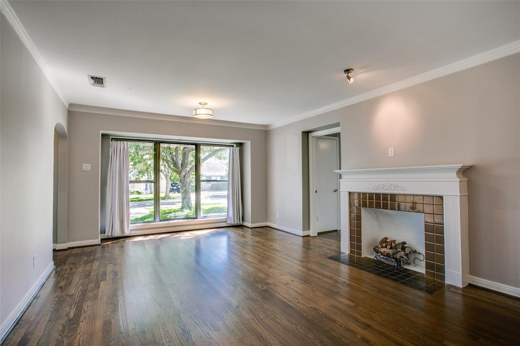 2051 Marydale Road Dallas, TX 75208 - Photo 10 of 30 an empty room with wooden floor fireplace and windows
