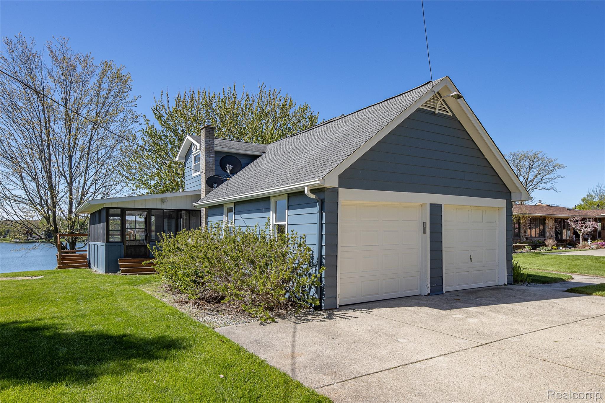 2855 Farmers Creek Road Metamora, MI 48455 - Photo 5 of 51 Light blue siding exterior with a screened porch overlooking a body of water