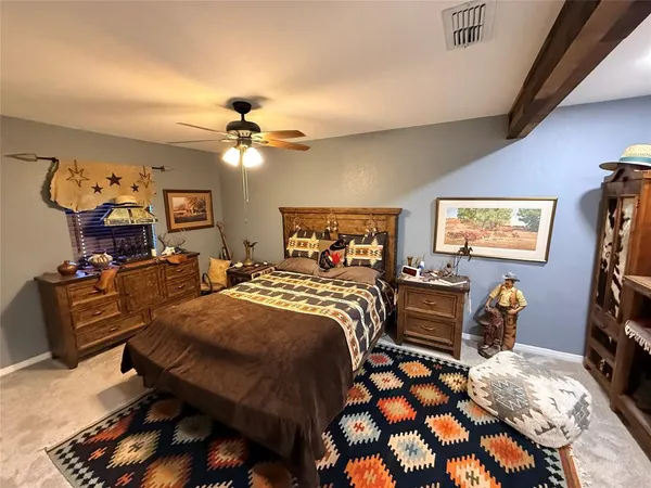 a bedroom with a bed and dresser with chair