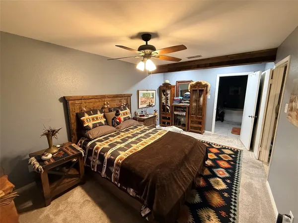 a bedroom with a large bed and a chandelier