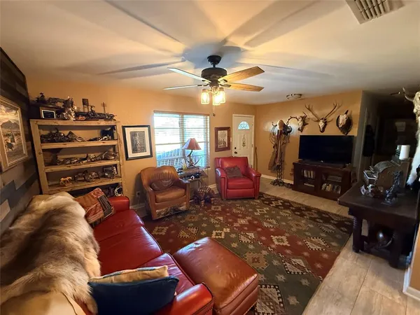 a living room with furniture a flat screen tv and a window