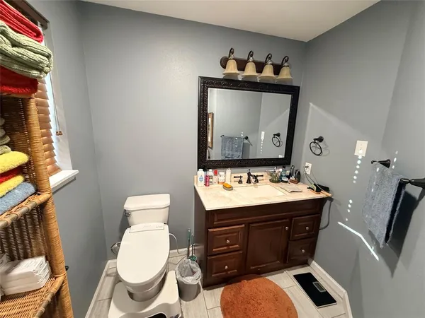 a bathroom with a toilet a sink and mirror