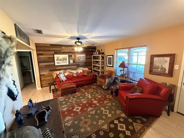 a living room with furniture a flat screen tv and a window