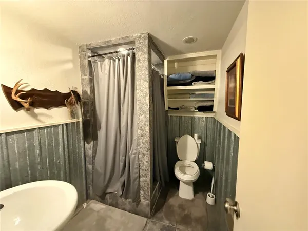 a bathroom with a toilet sink and mirror
