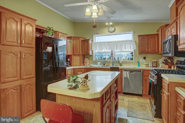 a kitchen with a refrigerator a stove a sink a dining table and chairs