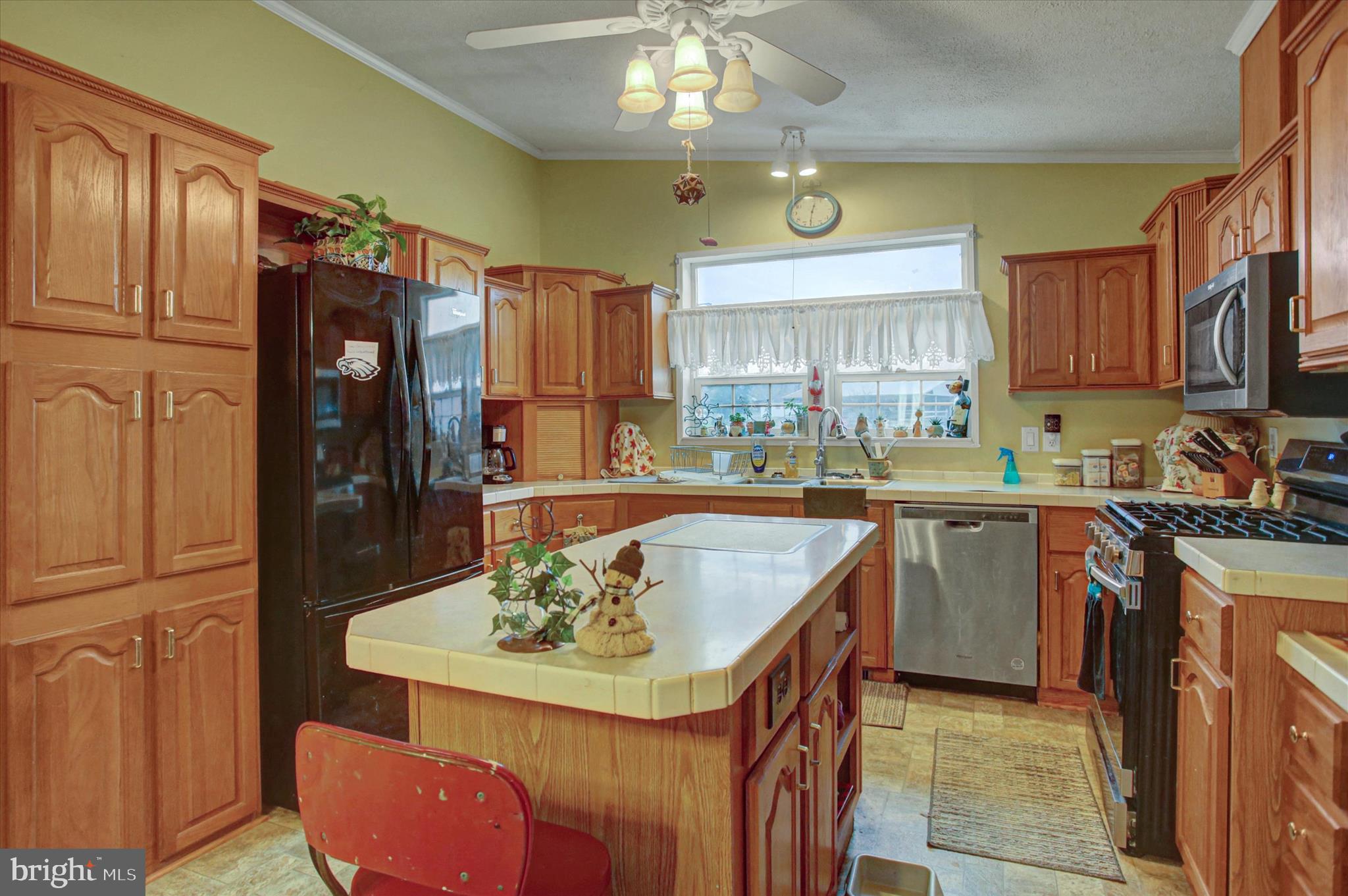 21571 Path Valley Road Dry Run, PA 17220 - Photo 15 of 63 a kitchen with a refrigerator a stove a sink a dining table and chairs