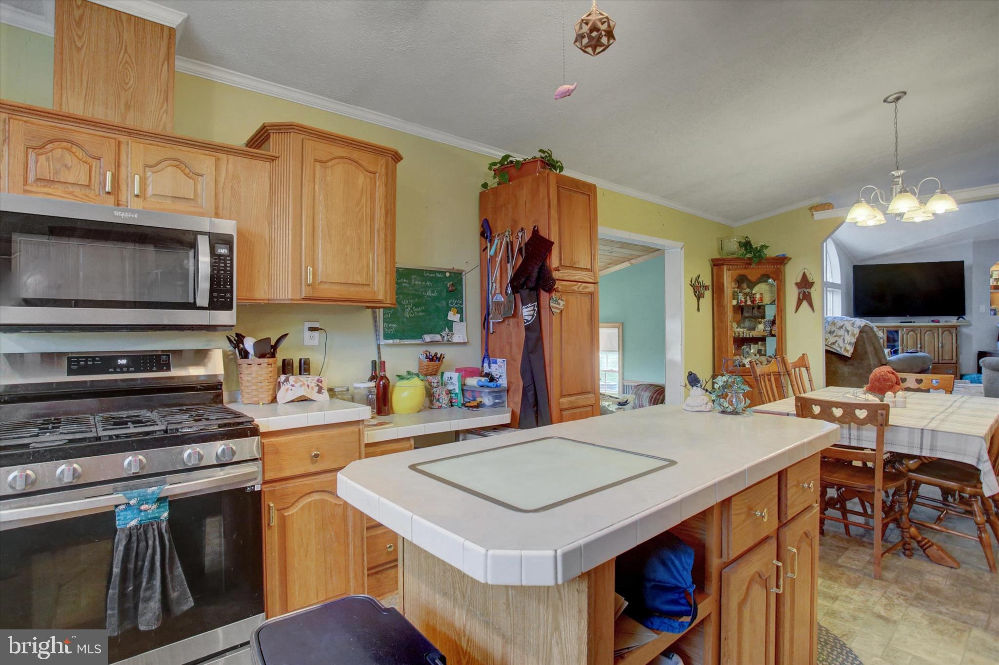 21571 Path Valley Road Dry Run, PA 17220 - Photo 21 of 63 a kitchen with a stove a sink dishwasher and a microwave oven with a dining table