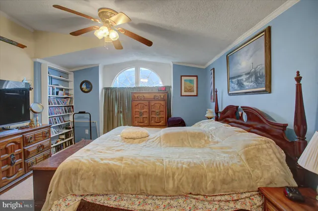 a bed sitting in a bedroom next to a dresser with wooden floor