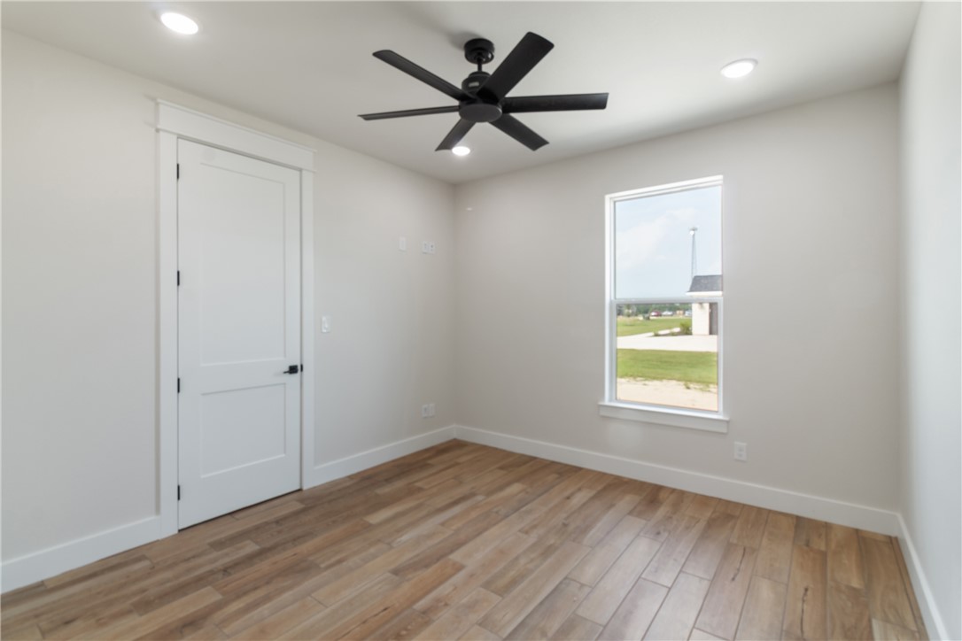 7822 Mathis Crk Drive Bryan, TX 77808 - Photo 24 of 43 wooden floor in an empty room with a window