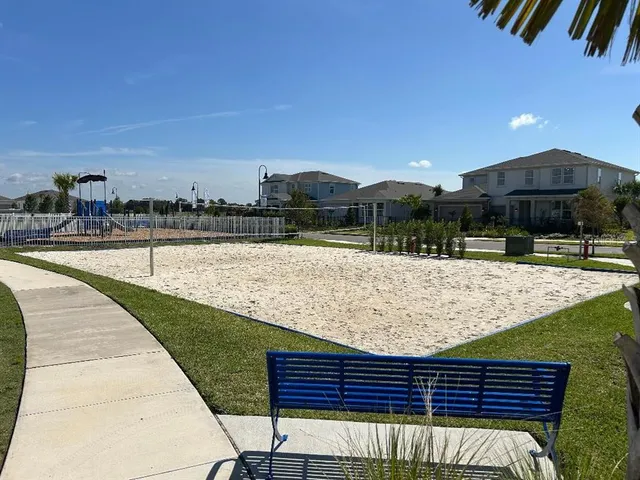 a view of a tennis ground with large trees