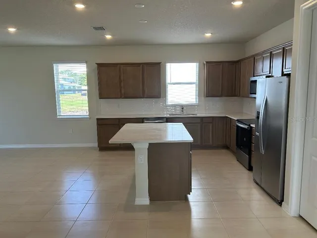a kitchen with stainless steel appliances granite countertop a sink counter space cabinets and a window