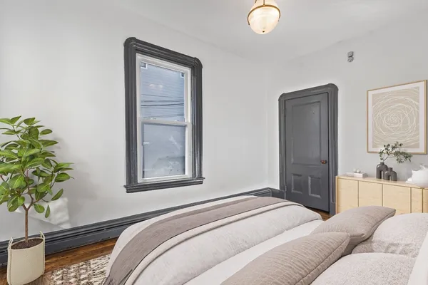 a bedroom with a bed and a potted plant