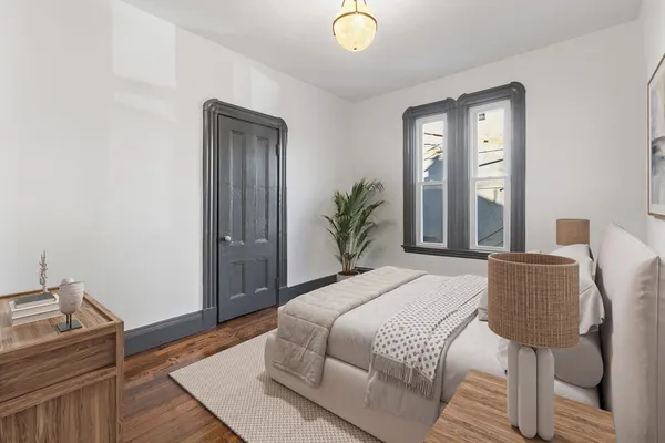 a bedroom with a bed and wooden floor