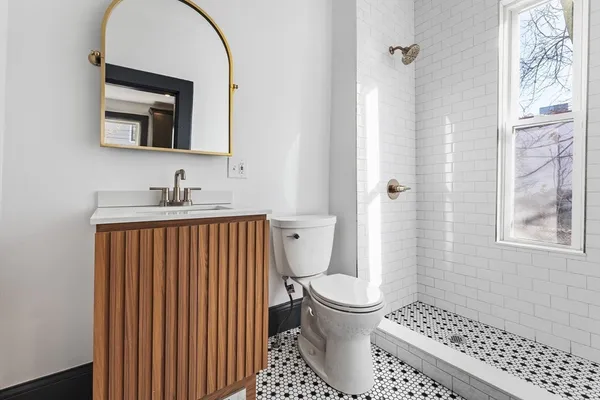 a bathroom with a toilet a sink and a mirror