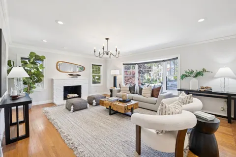 a living room with furniture a fireplace and a chandelier
