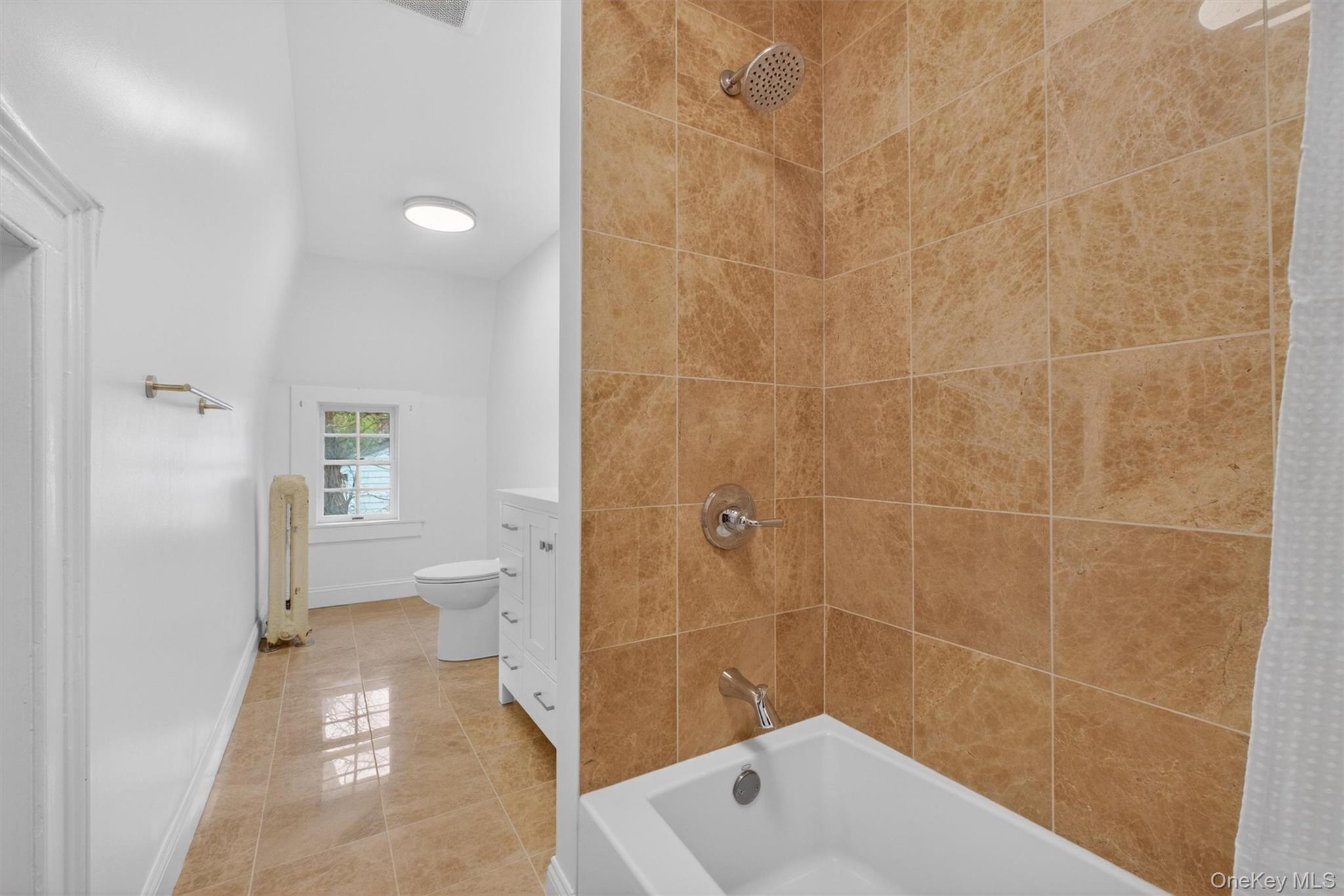 121 Old Glenham Road Fishkill, NY 12524 - Photo 26 of 50 Bright bathroom featuring a tiled shower surround, integrated bathtub, and a modern vanity with cabinet storage