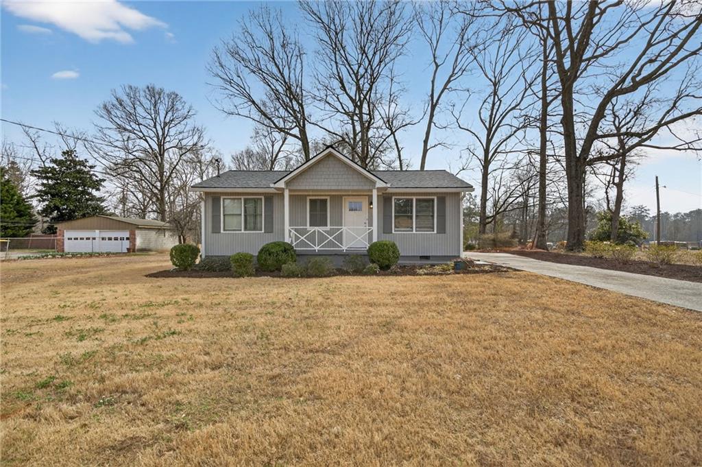 a front view of a house with yard and trees