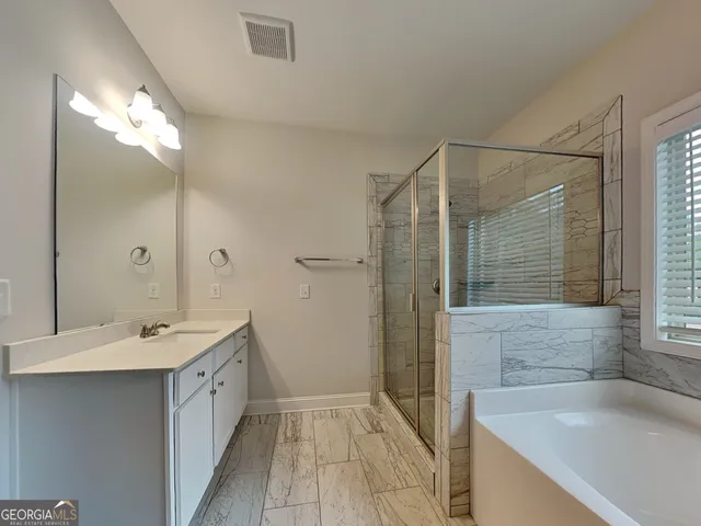 a bathroom with a tub sink and mirror