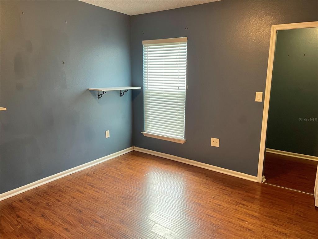 2564 Islander Court Palm Harbor, FL 34683 - Photo 18 of 21 an empty room with wooden floor and windows