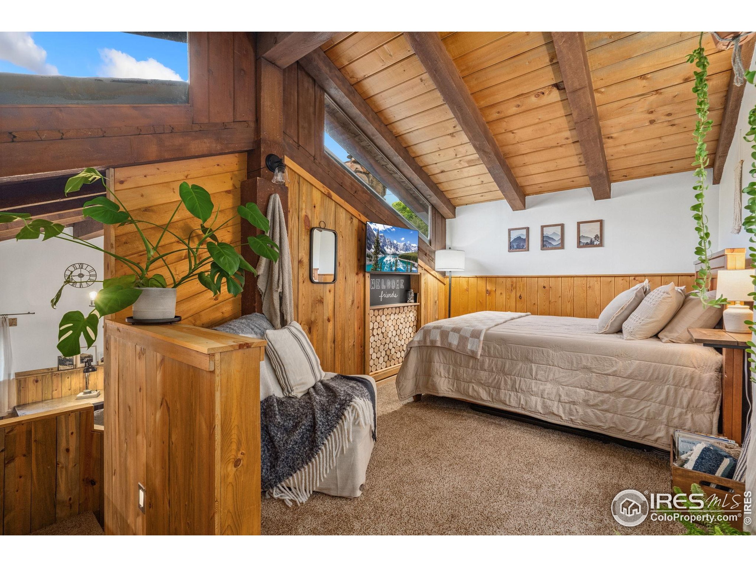 32224 Poudre Canyon Road Bellvue, CO 80512 - Photo 15 of 34 a bedroom with a bed and wooden floor