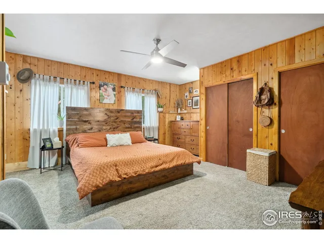 a bedroom with a bed dresser and a large window