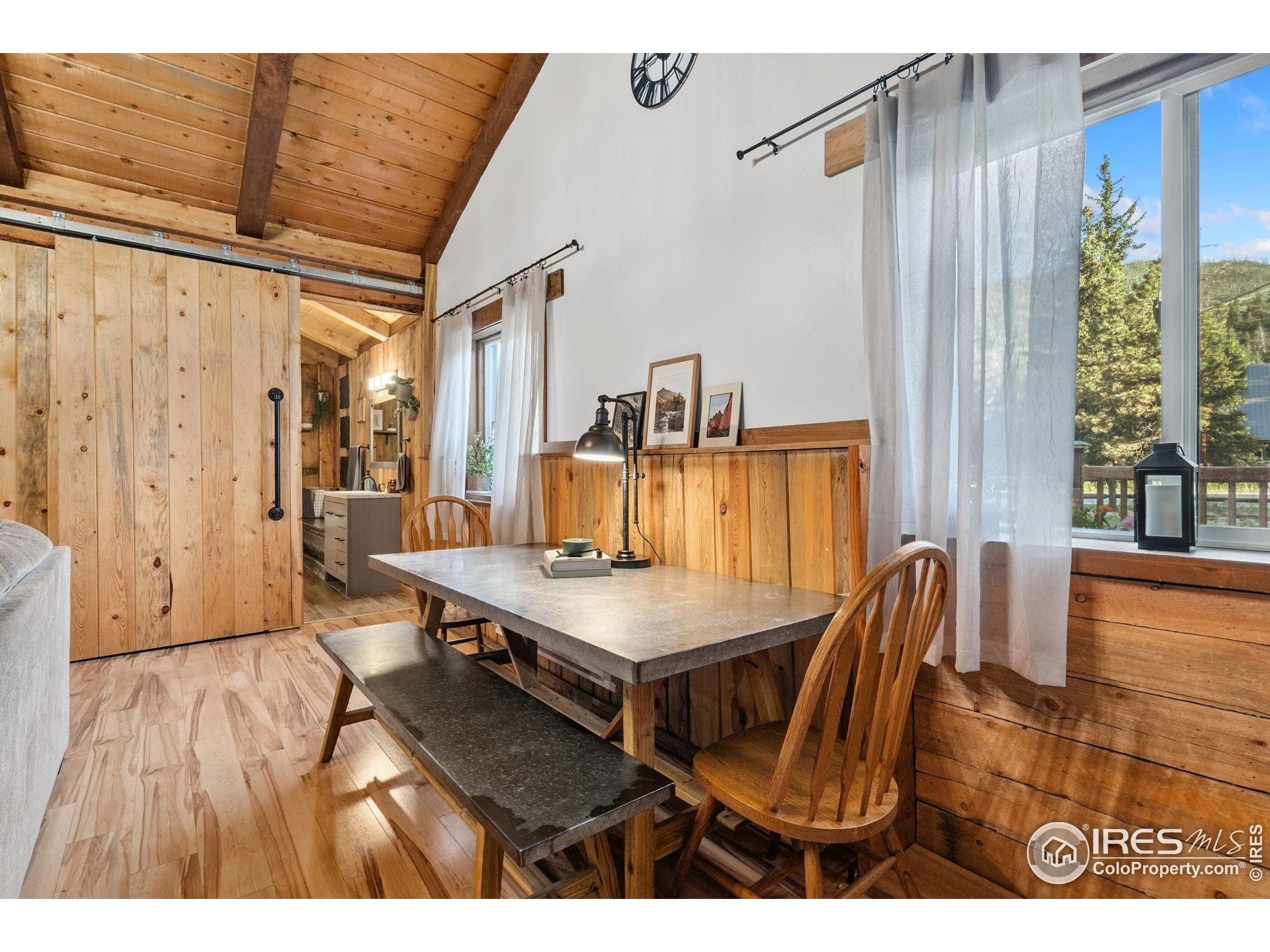 32224 Poudre Canyon Road Bellvue, CO 80512 - Photo 22 of 34 a view of a dining room with furniture and wooden floor