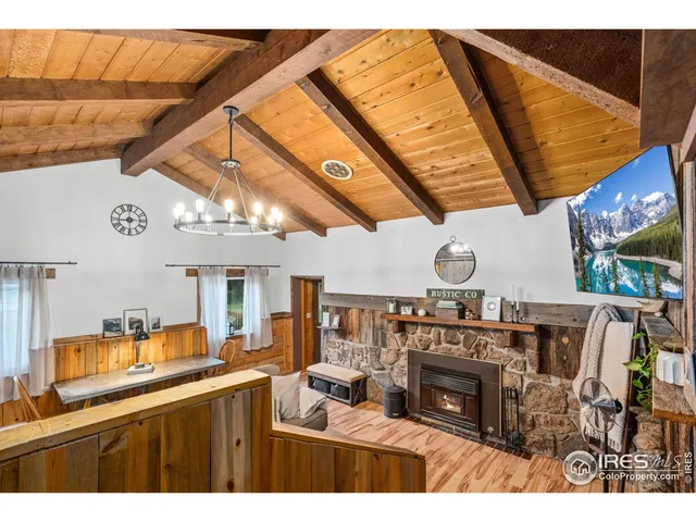 a kitchen with a wooden floor a fireplace a flat screen tv and a sink