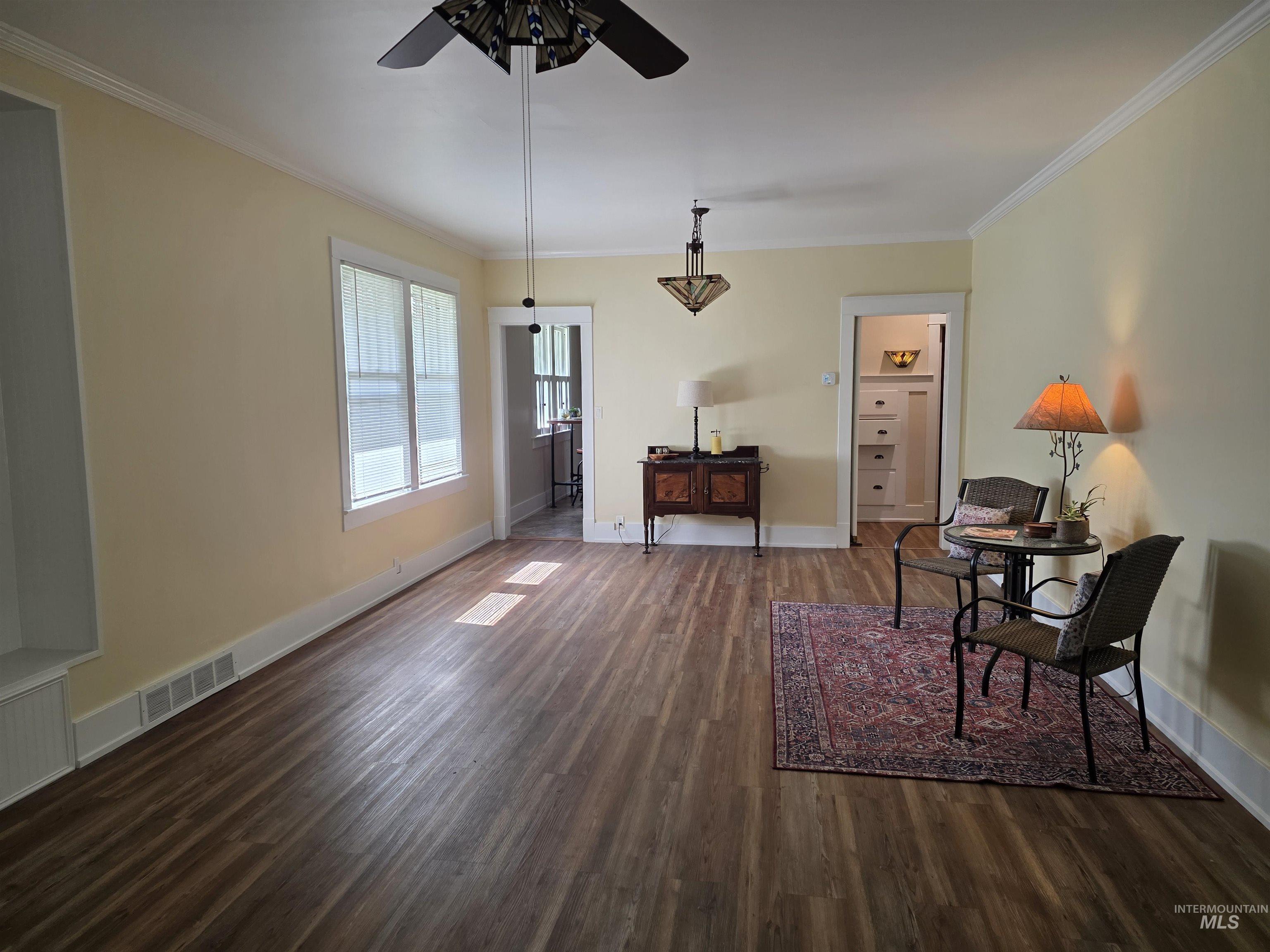 421 East Main Street Jerome, ID 83338 - Photo 5 of 13 Spacious interior featuring wood-finish flooring, two windows, and a built-in shelving unit