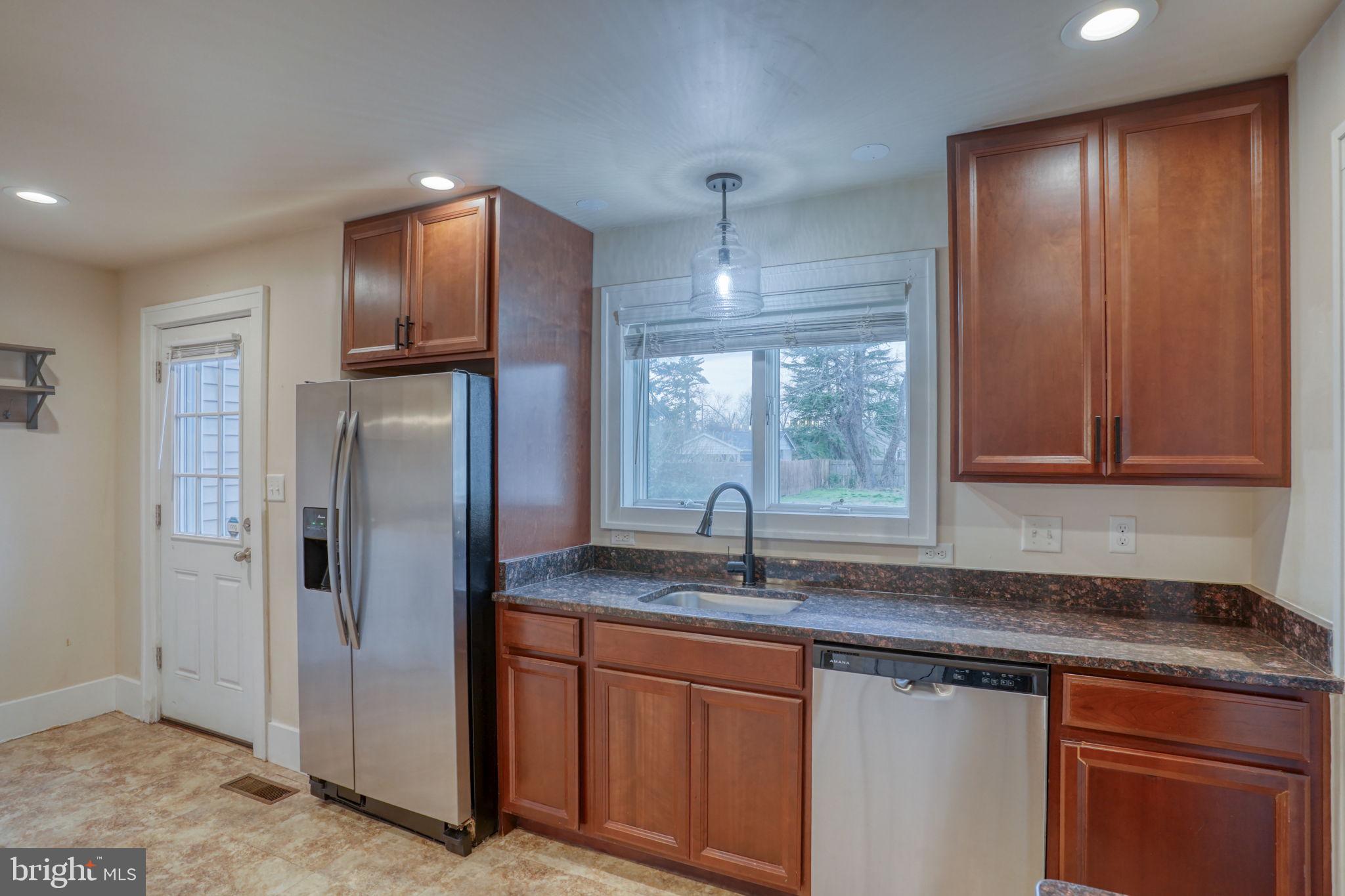 129 Laurel Road Millsboro, DE 19966 - Photo 14 of 40 a kitchen with stainless steel appliances granite countertop a refrigerator and a sink
