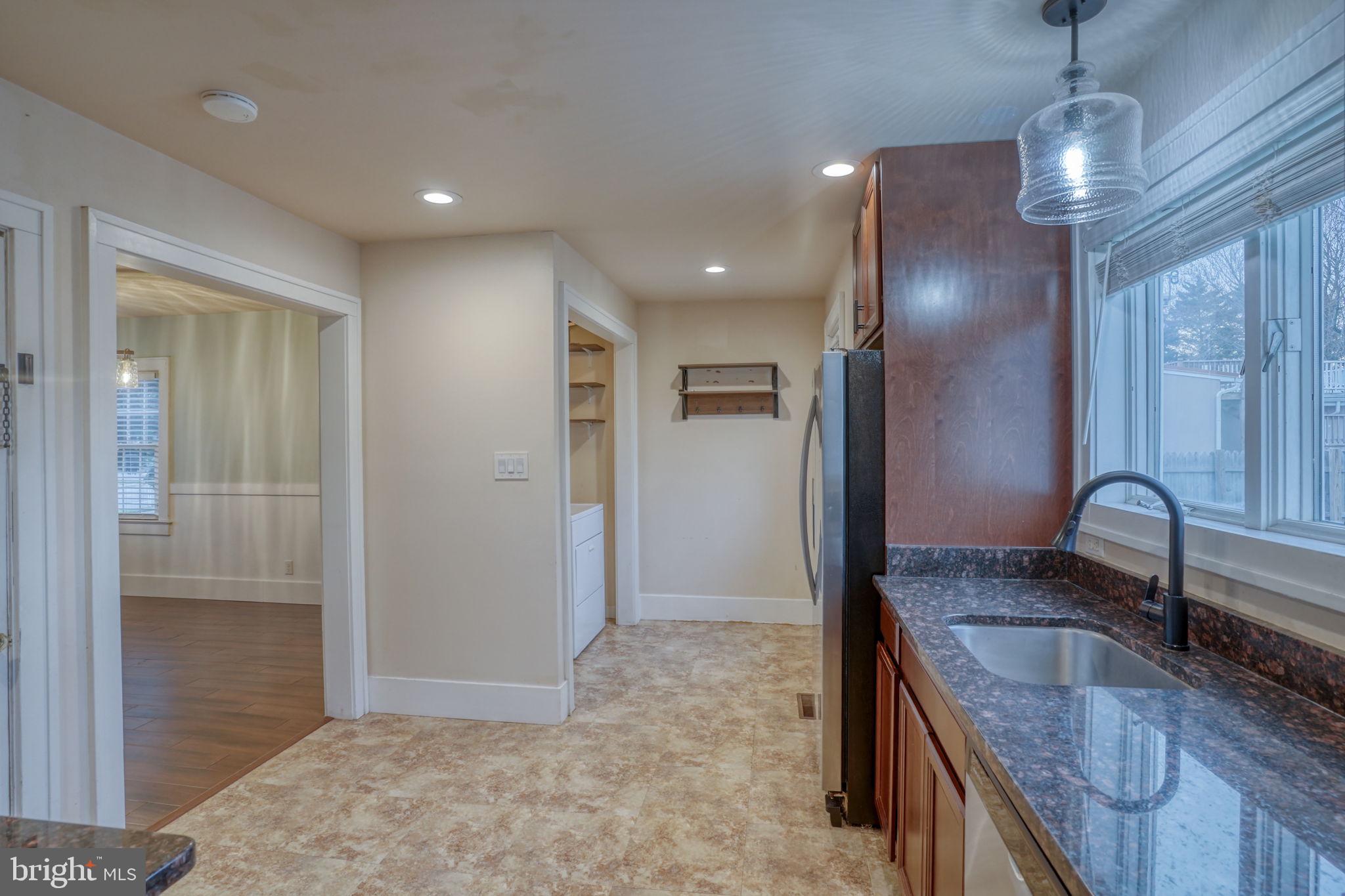 129 Laurel Road Millsboro, DE 19966 - Photo 17 of 40 a kitchen with granite countertop a sink and refrigerator