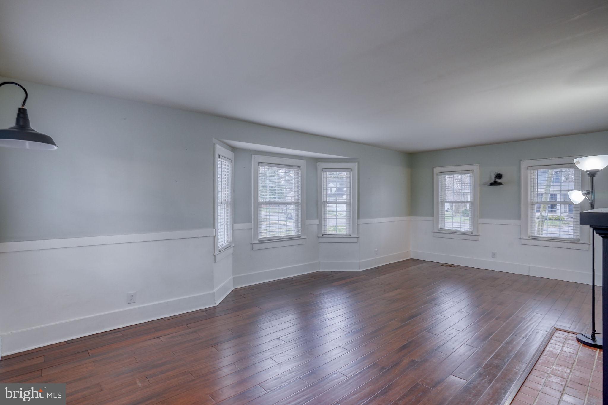 129 Laurel Road Millsboro, DE 19966 - Photo 20 of 40 an empty room with wooden floor and windows