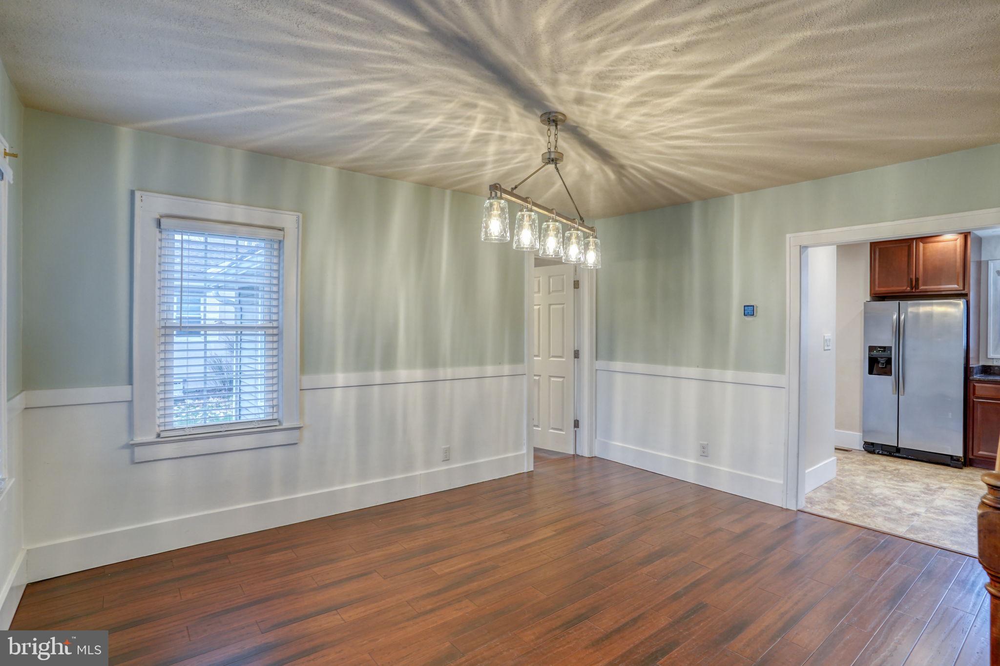 129 Laurel Road Millsboro, DE 19966 - Photo 8 of 40 a view of an empty room with wooden floor and a window