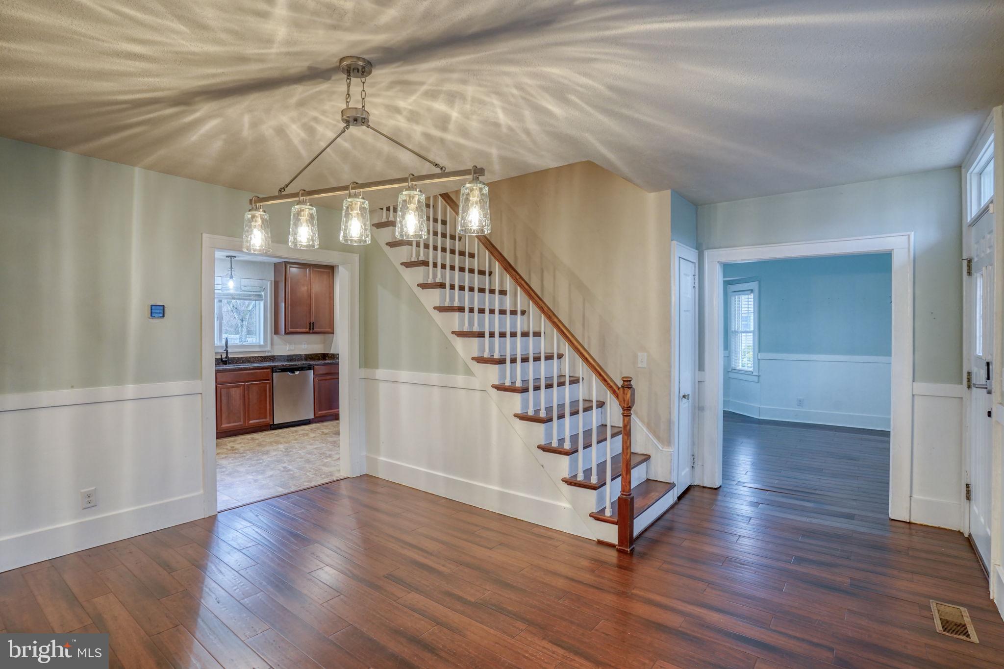 129 Laurel Road Millsboro, DE 19966 - Photo 10 of 40 a view of a hallway with wooden floor stairs and a chandelier