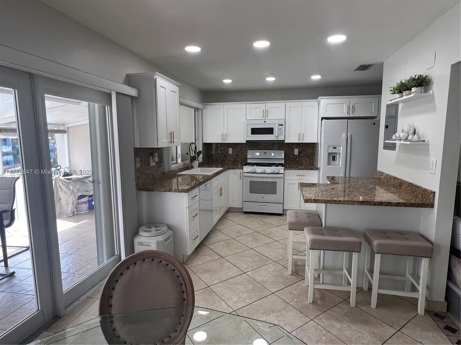 6936 Holly Road Miami Lakes, FL 33014 - Photo 15 of 43 Newer kitchen cabinets and appliances, gas stove, cozy breakfast counter.