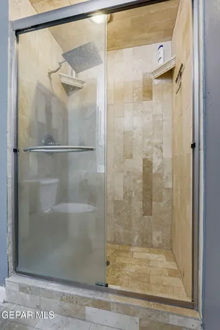 a kitchen with granite countertop a refrigerator sink and white cabinets