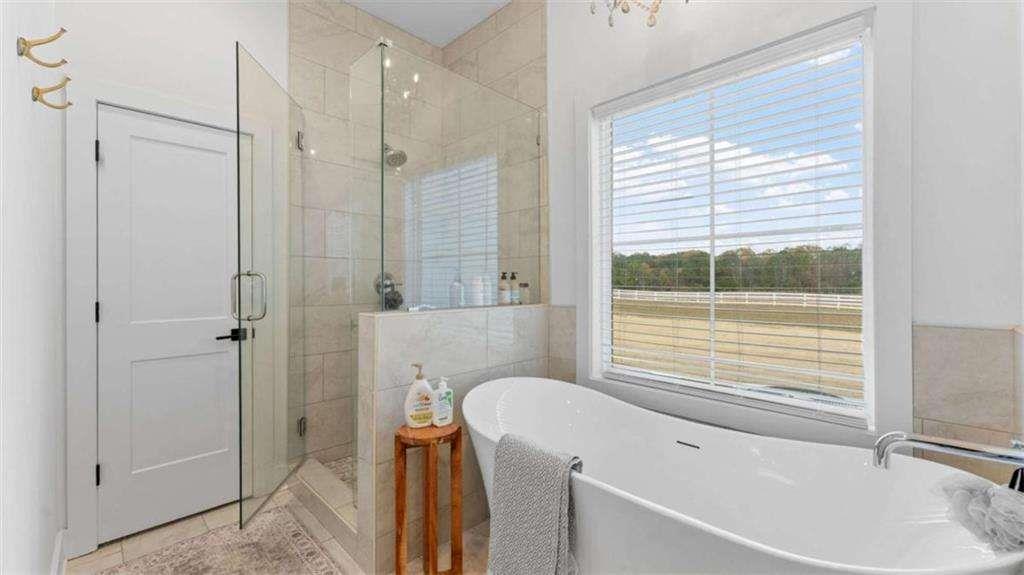 28 Ravenfield Road Taylorsville, GA 30178 - Photo 18 of 38 a bathroom with a tub a window and a shower